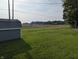 View of the backyard, featuring a small outbuilding, and lush green lawn at 4740 Milton St, Coatesville, IN 46121