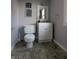 A small bathroom with gray walls features a toilet, a vanity with a white cabinet and nautical decor at 4740 Milton St, Coatesville, IN 46121