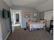 A cozy bedroom with carpet, featuring a single bed, decorations, and a TV at 4740 Milton St, Coatesville, IN 46121
