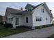 Exterior view showcases white siding, windows, covered porch, American flag, and a well-manicured lawn at 4740 Milton St, Coatesville, IN 46121
