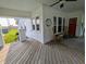 Spacious front porch with wooden flooring, rocking chairs, decorative stone pillars, and a clear view of the yard at 4740 Milton St, Coatesville, IN 46121