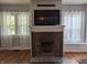 Living room with a brick fireplace, white mantel, and large windows providing ample natural light at 4740 Milton St, Coatesville, IN 46121