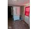 View of the kitchen, with white refrigerator, wood floor, and red curtain at 489 W Sumner Ave, Martinsville, IN 46151