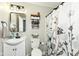 Bathroom with a floral shower curtain, black framed mirror, and updated lighting at 504 Broadway Ave, Arcadia, IN 46030