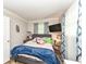 Bedroom with wood floor features a grey bed frame, light pink bedding, and a mounted television at 504 Broadway Ave, Arcadia, IN 46030