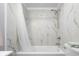 The bathroom with white marble-style tile, a shower with curtain, and a toilet at 533 Patterson Rd, Columbus, IN 47203