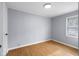 The bedroom has light gray walls and light colored hardwood floors, with a window at 533 Patterson Rd, Columbus, IN 47203