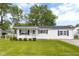 Charming single-story home with a well-maintained lawn and mature trees under a sunny, partly cloudy sky at 533 Patterson Rd, Columbus, IN 47203