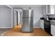 Kitchen features stainless steel refrigerator and white cabinets and laminate floor at 533 Patterson Rd, Columbus, IN 47203