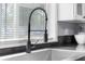 A close up of the kitchen sink with a spring faucet and gray countertops at 533 Patterson Rd, Columbus, IN 47203