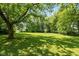 Expansive backyard with mature trees offering shade and a lush lawn at 5719 N Frontage Rd, Fairland, IN 46126
