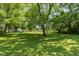 Spacious backyard surrounded by mature trees, perfect for outdoor activities at 5719 N Frontage Rd, Fairland, IN 46126