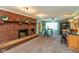 Open-concept living room with brick fireplace, dining area, and abundant natural light at 5719 N Frontage Rd, Fairland, IN 46126