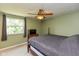 Comfortable bedroom features natural light, a ceiling fan, and neutral carpeting at 5802 Rymark Ct, Indianapolis, IN 46250