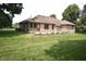Scenic backyard showcasing a brick home with a screened-in porch and lush green lawn at 5943 Red Maple Dr, Indianapolis, IN 46237