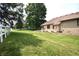 Expansive backyard with a well-maintained lawn, bordered by mature trees and a white fence, offering privacy at 5943 Red Maple Dr, Indianapolis, IN 46237