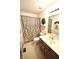 A bathroom featuring a vanity with wood cabinets, a neutral colored shower curtain and a wreath above the towel bar at 5943 Red Maple Dr, Indianapolis, IN 46237
