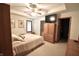 A bedroom with a ceiling fan, a flat-screen TV above a wooden cabinet, and a bed with neutral colored bedding at 5943 Red Maple Dr, Indianapolis, IN 46237