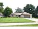 Well-manicured front yard showcasing the home's brick facade, complemented by lush greenery and mature trees at 5943 Red Maple Dr, Indianapolis, IN 46237