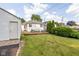 Spacious backyard featuring a lush lawn, detached garage, and a cozy deck with outdoor seating, perfect for leisure at 6045 Crittenden Ave, Indianapolis, IN 46220