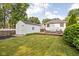 A well-manicured backyard features a wooden deck with outdoor seating and a detached garage, perfect for relaxation and storage at 6045 Crittenden Ave, Indianapolis, IN 46220