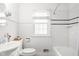 Clean and bright bathroom with white tile, a classic tub, and stylish fixtures at 6045 Crittenden Ave, Indianapolis, IN 46220