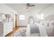 Light, bright bedroom with ceiling fan, whitewashed floors, and decorative white bedding at 6045 Crittenden Ave, Indianapolis, IN 46220
