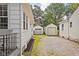 View of detached garages in the rear with gravel driveway and glimpse of siding on nearby homes at 6045 Crittenden Ave, Indianapolis, IN 46220