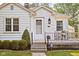 Charming home exterior featuring a small front porch, detailed stonework, and landscaped garden beds at 6045 Crittenden Ave, Indianapolis, IN 46220