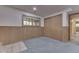 Neutral finished basement area with wall paneling and a large window for natural light at 617 Echo Bend Blvd, Greenwood, IN 46142