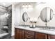 Bathroom featuring double sinks, granite countertops, modern fixtures, a tiled shower, and dark tile floors at 624 E Walnut St # 48, Indianapolis, IN 46204