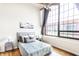 Comfortable bedroom featuring a large window, modern ceiling fan, and neutral décor at 624 E Walnut St # 48, Indianapolis, IN 46204