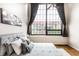Bright bedroom featuring a large window with neighborhood views and a comfortable bed with plush pillows at 624 E Walnut St # 48, Indianapolis, IN 46204
