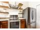 Modern kitchen with stainless steel appliances, wooden cabinets, and stylish open shelves at 624 E Walnut St # 48, Indianapolis, IN 46204