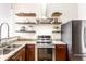 Well-equipped kitchen featuring stainless steel appliances, granite countertops, and open shelving at 624 E Walnut St # 48, Indianapolis, IN 46204