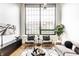 Bright living room featuring hardwood floors, a large window, stylish decor and modern furnishings at 624 E Walnut St # 48, Indianapolis, IN 46204