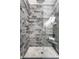 Tiled shower with glass door, rain shower head, a built-in bench, and stone floor tiles at 624 E Walnut St # 48, Indianapolis, IN 46204