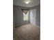 A carpeted bedroom featuring neutral walls, a window with valance, and a closet with bi-fold doors at 7307 Barnwell Pl, Indianapolis, IN 46217