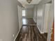 Inviting hallway with modern wood flooring, neutral paint, and an open view into the living area at 7307 Barnwell Pl, Indianapolis, IN 46217
