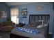 Comfortable bedroom featuring a bed, carpet, large window and a sitting area with an accent chair at 7357 Lake Lakota Dr, Indianapolis, IN 46217