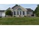 Charming brick home featuring a well-manicured lawn, trimmed shrubs, and a cozy front porch at 7357 Lake Lakota Dr, Indianapolis, IN 46217