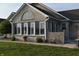 Beautiful brick home featuring large windows, a well-manicured lawn, and a welcoming sunroom at 7357 Lake Lakota Dr, Indianapolis, IN 46217