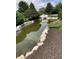 A serene community pond with rock and mulch edging plus a charming white bridge at 7357 Lake Lakota Dr, Indianapolis, IN 46217