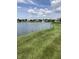 Pond view showcasing well-maintained lawns and community homes in the distance at 7357 Lake Lakota Dr, Indianapolis, IN 46217