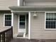 Back entrance featuring a white door with glass and an adjacent deck area, framed by the home's siding at 7667 Madden Ln, Fishers, IN 46038