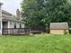 Backyard featuring a wooden deck, a storage shed, a brick chimney, and a spacious grassy area at 7667 Madden Ln, Fishers, IN 46038