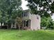 Image shows the side exterior of a two-story home with siding, black shutters, and a fenced yard at 7667 Madden Ln, Fishers, IN 46038