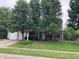 Charming two-story home featuring a well-maintained front yard with mature trees, lawn, and a driveway at 7667 Madden Ln, Fishers, IN 46038