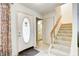 Bright foyer featuring a staircase and a view into the bathroom at 7724 Eagle Valley Pass, Indianapolis, IN 46214