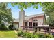 Back exterior view featuring spacious wooden deck, lush landscaping, and grill at 7831 Bayridge Dr, Indianapolis, IN 46236